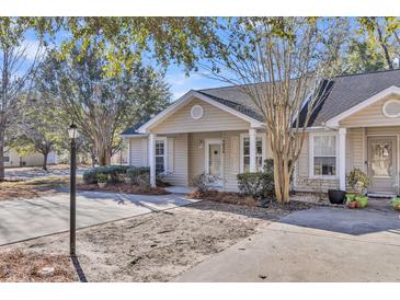 Tan colored house with white trim and a small front yard at 7936 Vermont Rd, North Charleston, SC 29418