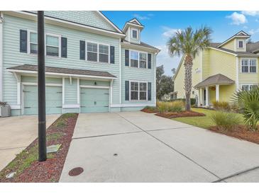 Front view of two-story townhouses with attached garages and landscaped yards at 1455 Red Tide Rd, Mount Pleasant, SC 29466