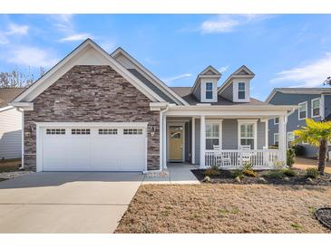 Gray house with stone accents, white garage door, and a welcoming front porch at 2015 Barn Swallow Rd, Summerville, SC 29483