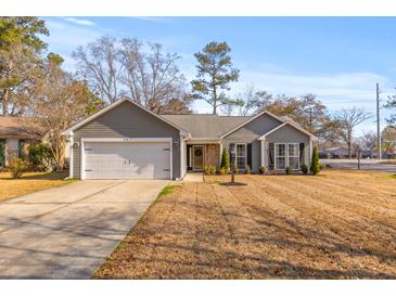 Gray house with white garage door, landscaping, and a driveway at 302 Damascus Dr, Summerville, SC 29483