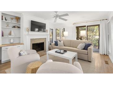 Bright living room with fireplace, built-ins, and access to patio at 4545 Park Lake Dr, Kiawah Island, SC 29455