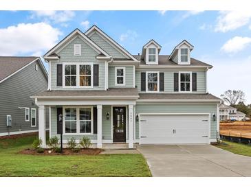 Two-story house with light green siding, white garage door, and landscaped lawn at 738 Maynard Ln, Summerville, SC 29486