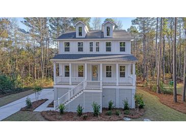 Charming two-story home with white siding, dormer windows, and inviting front porch at 0 United Dr, Huger, SC 29450
