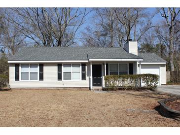 Tan vinyl-sided house with gray roof, black shutters, and small porch at 186 Bridgecreek Dr, Goose Creek, SC 29445
