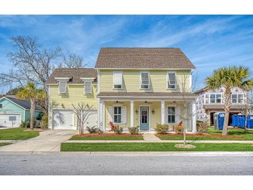 Two-story yellow house with white columns, shutters, and a two-car garage at 2725 Battery Pringle Dr, Johns Island, SC 29455