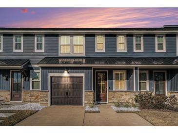 Modern two-story townhome with dark gray siding, stone accents, and a dark brown garage door at 5135 Park Creek Avenue, North Charleston, SC 29418