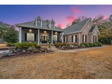 Brick and gray two-story home with landscaped yard and porch at 788 Awendaw Lakes Blvd, Awendaw, SC 29429