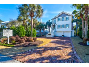 Beautiful two-story home features palm trees, lush landscaping, and a brick driveway at 120 Charleston Blvd, Isle of Palms, SC 29451