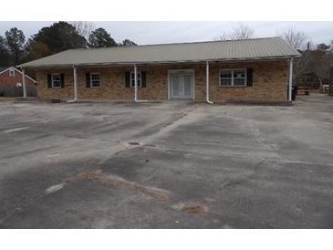 Inviting single-story brick house with a metal roof and a spacious parking lot at 1382 Doctor Evans Rd, Moncks Corner, SC 29461