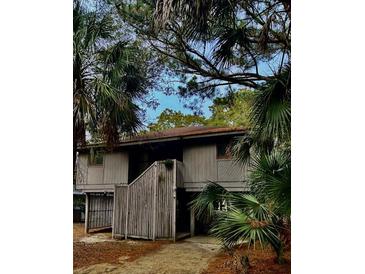 Charming two-story home with a wooden fence and beautiful natural landscaping at 16 Twin Oaks Lane Ln, Isle of Palms, SC 29451