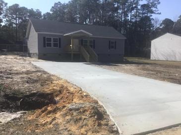 Charming single-story home with gray siding, black shutters, and a new concrete driveway at 183 Waverly Rd, Walterboro, SC 29488