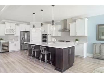Bright, modern kitchen features stainless steel appliances, a wine fridge, and a large kitchen island with barstool seating at 2094 Cousteau Ct, Johns Island, SC 29455