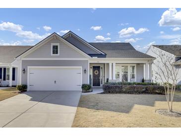 Charming single-story home with a well-manicured lawn, inviting front porch, and attached two-car garage at 376 Tupelo Lake Dr, Summerville, SC 29486