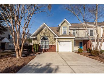 Inviting townhome featuring an attached garage and manicured landscaping in a suburban neighborhood at 5215 Chicory Ln, North Charleston, SC 29420