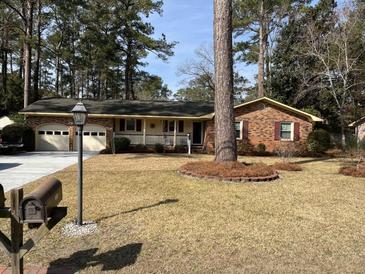 Charming brick home featuring a well-manicured lawn, attached garage, and welcoming front porch, perfect for enjoying the outdoors at 715 Old Golf Rd, Summerville, SC 29483