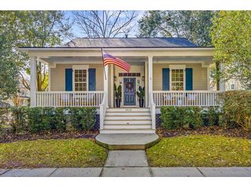 Charming home with a welcoming front porch, American flag, blue shutters, and well-maintained landscaping at 1013 Barfield St, Charleston, SC 29492