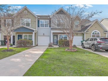 Charming townhomes with well-manicured lawns and driveways on a sunny day at 106 Kirkland St, Goose Creek, SC 29445