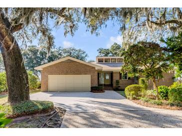 Charming brick home featuring a well-maintained lawn and a two-car garage at 119 Riverland Dr, Charleston, SC 29412