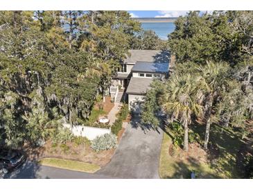 Charming home featuring lush landscaping, a private driveway, and a serene waterfront view at 161 Marsh Hawk Ln, Kiawah Island, SC 29455