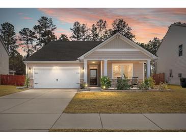 Charming single-Gathering home with a two-car garage, inviting porch and manicured lawn under a stunning sunset at 407 Squire Pope Rd, Summerville, SC 29486