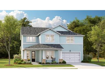 Charming two-story home with light blue siding, a covered porch, and a well-manicured front lawn at 207 Denham St, Summerville, SC 29486