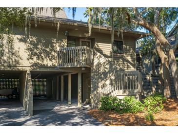 Charming two-story coastal home with covered parking, wooden stairs, and lush landscaping at 796 Summerwind Cir, Edisto Beach, SC 29438