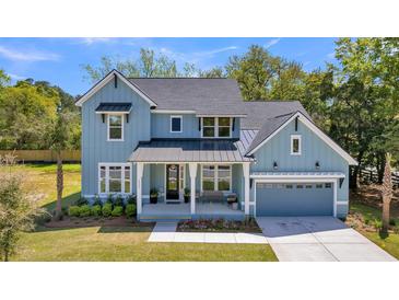 Charming light blue two-story home with a welcoming front porch and well-manicured lawn at 1184 Reserve Ln, Awendaw, SC 29429