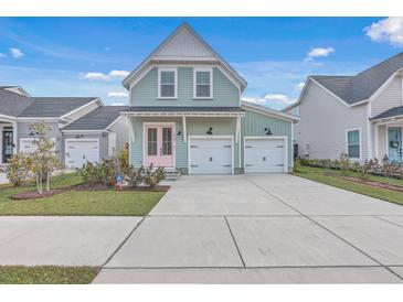 Charming two-story home featuring a pink front door, light green siding, and two-car garage at 219 Clearblue Loop, Summerville, SC 29486