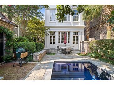 Charming backyard featuring a grill, patio dining set, and a refreshing in-ground swimming pool at 23 Elliott St, Charleston, SC 29401