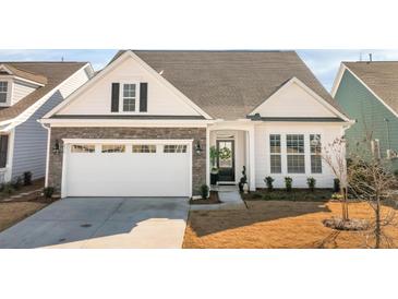 Charming home featuring stone accents, white siding, a two-car garage, and a beautifully landscaped front yard at 236 River Martin Ct, Summerville, SC 29483