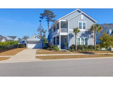 Charming two-story home boasts a welcoming porch and an attached garage with beautifully landscaped front yard at 2613 Hatch Dr, Johns Island, SC 29455