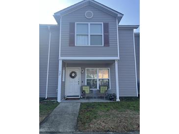 Charming two-story home with a welcoming front porch featuring comfortable seating and a decorative wreath at 527 Travelers Blvd, Summerville, SC 29485