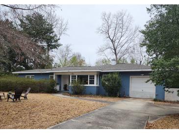 Charming single-story blue home featuring a well-manicured lawn, a driveway and an attached single-car garage at 1216 Eastwood Ave, Hanahan, SC 29410