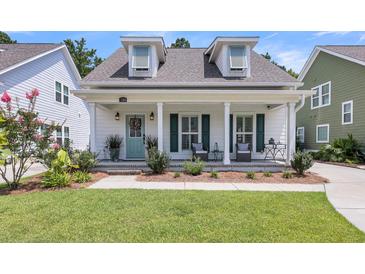 Charming single-Gathering home with a welcoming front porch, well-maintained lawn, and beautiful landscaping at 1710 Sparkleberry Ln, Johns Island, SC 29455