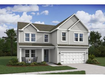 Charming two-story home with a welcoming front porch, attached two car garage and well-manicured lawn at 2014 Mcguire Ln # 004, Hollywood, SC 29449