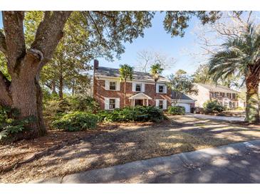 Charming two-story brick home featuring white shutters, a well-manicured lawn, and mature trees at 210 Lakeview Dr, Summerville, SC 29485