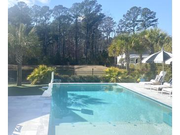 Inviting backyard pool with lounge chairs and a well-maintained lawn, perfect for relaxation and outdoor enjoyment at 3563 Bayden Bridge Ln, Mount Pleasant, SC 29466