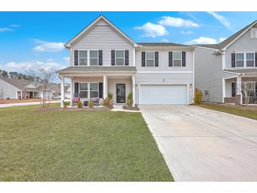 Charming two-story home with a well-manicured lawn and welcoming front porch at 428 Avocet Dr, Summerville, SC 29486