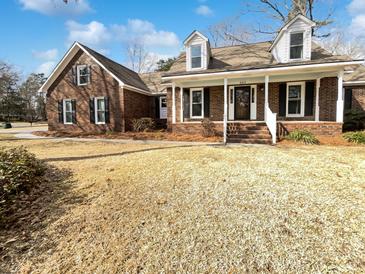 Charming brick home featuring a covered front porch, dormer windows and well maintained lawn at 503 Middleton Blvd, Summerville, SC 29485