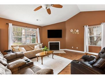 Inviting living room with a ceiling fan, large windows, fireplace, and comfortable seating arrangement at 7921 Cricket Ct # G, North Charleston, SC 29418