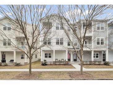 Charming exterior of a modern townhome featuring a welcoming front porch and an American flag at 129 Sabal Ct, Summerville, SC 29483