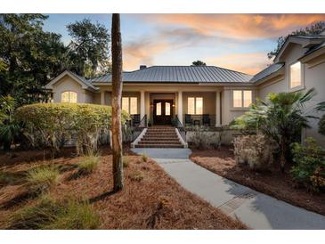 Stately home with a covered porch, columns, and a brick staircase leading to double front doors at 2455 The Haul Over, Seabrook Island, SC 29455