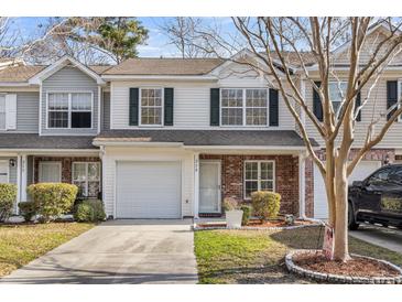 Charming townhome featuring a one-car garage and a well-maintained front yard with mature landscaping at 250 Xavier St, Charleston, SC 29414