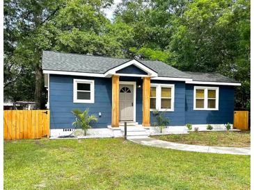 Charming home featuring a freshly landscaped front yard, updated windows, and a beautifully painted exterior at 4530 Holly St, North Charleston, SC 29405