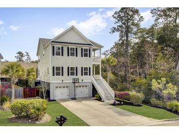 Charming three-story home with a two-car garage, a basketball hoop, and a beautifully landscaped yard at 494 Sanders Farm Ln, Charleston, SC 29492