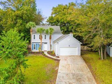 Charming two-story home featuring a well-manicured lawn, mature trees, and attached garage at 1294 Horseshoe Bnd, Mount Pleasant, SC 29464