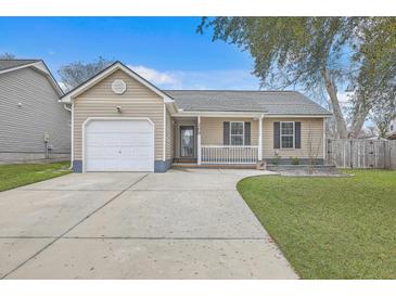 Charming single-story home with a well-manicured lawn, attached garage, and inviting front porch at 209 Persimmon Cir, Goose Creek, SC 29445