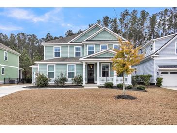 Charming two-story home features a welcoming front porch and manicured landscaping at 295 Calm Water Way, Summerville, SC 29486