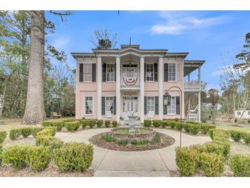 Charming two-story home with columns, fountain and landscaped front yard at 301 E Richardson Ave, Summerville, SC 29483