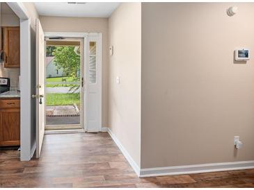Inviting foyer featuring wood-look floors and a view of the outdoors through the storm door at 303 Hamlet Rd, Summerville, SC 29485